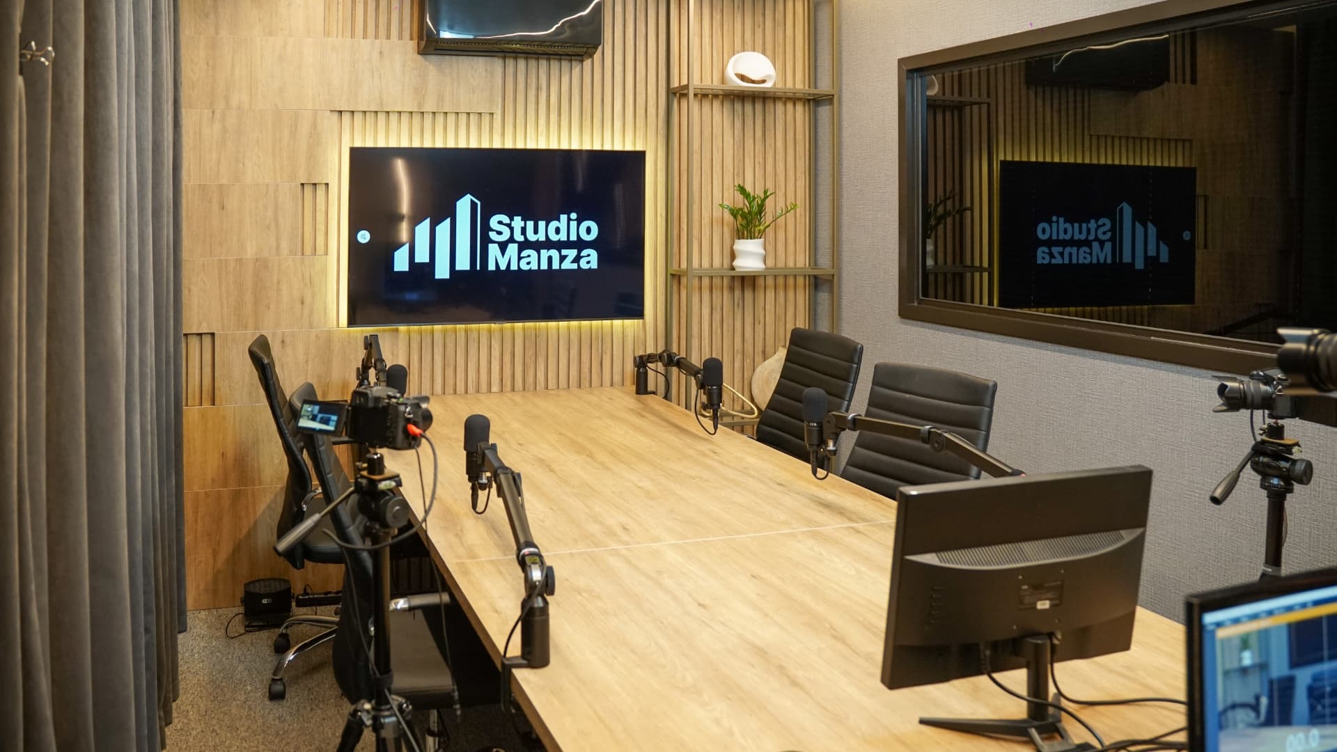 Sala de gravação do Manza Studio com painéis de madeira e microfones