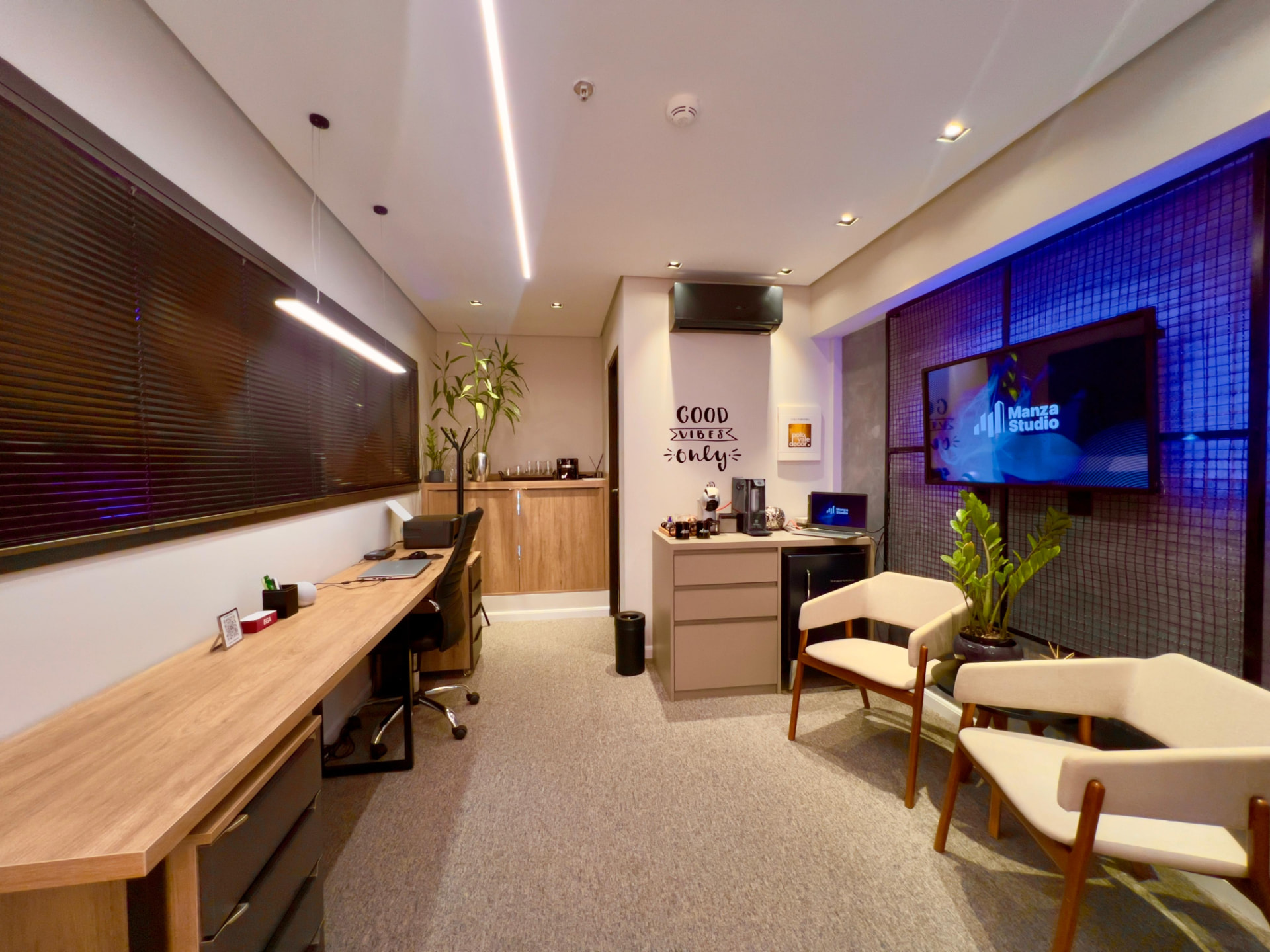 Sala interativa do Manza Studio com tela de apresentação e lounge